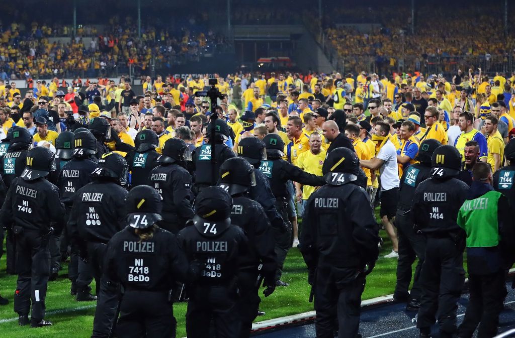 Die Beamten schützen nach dem Platzsturm den Fanblock des VfL Wolfsburg.
