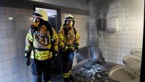 Feuerwehrkräfte in der Schultoilette, hinten der angezündete Handtuchhalter Foto: Alexander Ernst (Feuerwehr Fellbach)