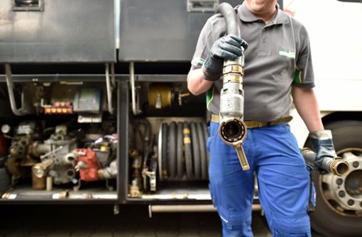 Ein Heizöl-Tankwagenfahrer zieht den Schlauch zum Betanken mit Heizöl zu einem Mehrfamilienhaus. Foto: dpa