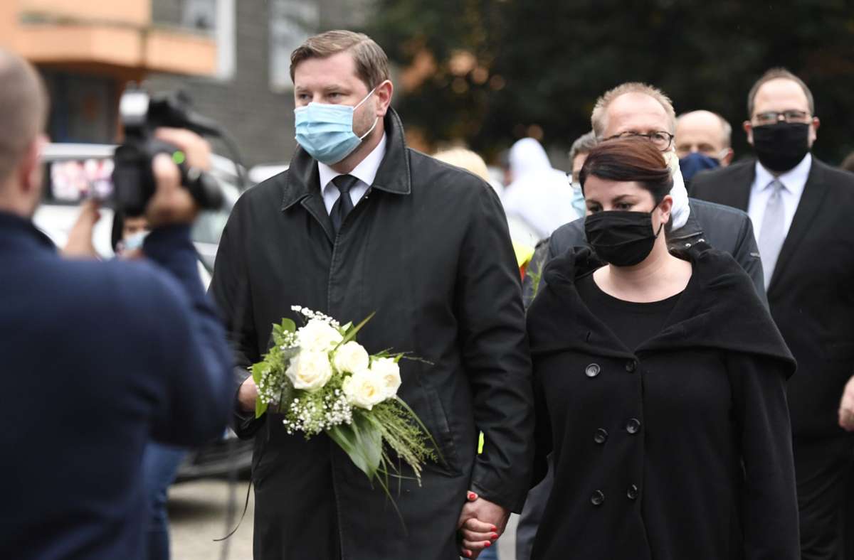 Der Oberbürgermeister von Solingen, Tim Kurzbach (SPD), und seine Frau Ursula Linda, legen an einem Wohnhaus Blumen zum Gedenken an die fünf toten Kinder ab.