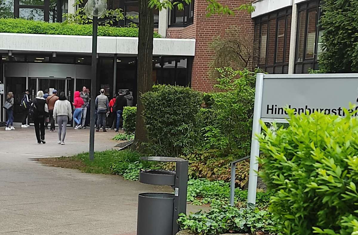 Vor dem Eingang des Kreishauses in Ludwigsburg bildet sich am Donnerstagvormittag eine kleine Menschentraube. Foto: hen