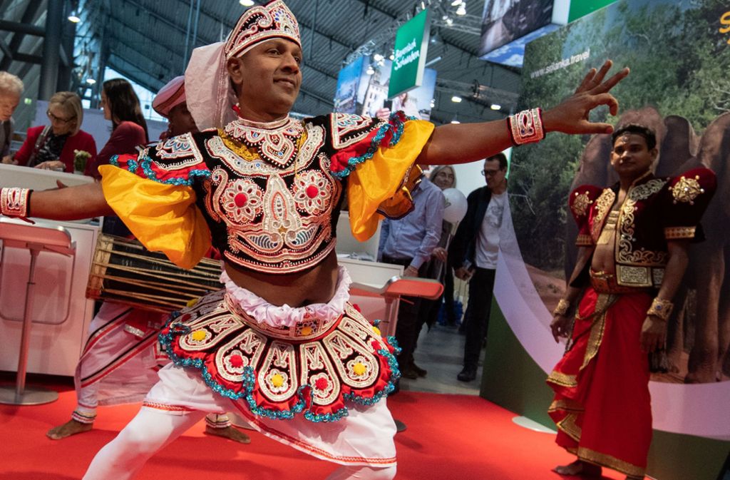 Ein Mann in traditioneller Kleidung tanzt am Stand von Sri Lanka auf der Reisemesse CMT
