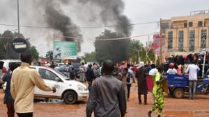 Über  Gebäuden in  der nigrischen Hauptstadt Niamey steigen Rauchwolken auf. Foto: AFP