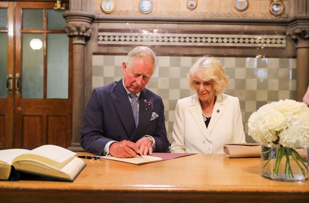 Prinz Charles und Herzogin Camilla tragen sich in das Kondolenzbuch ein.
