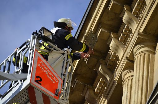 Ein Feuerwehrmann begutachtet den Schaden an der Fassade. Foto: Andreas Rosar Fotoagentur-Stuttg
