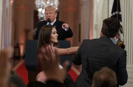 Präsident Donald Trump fixiert den CNN-Journalisten Jim Acosta, während eine Mitarbeiterin dem Journalisten das Mikrofon wegnimmt. Foto: AP