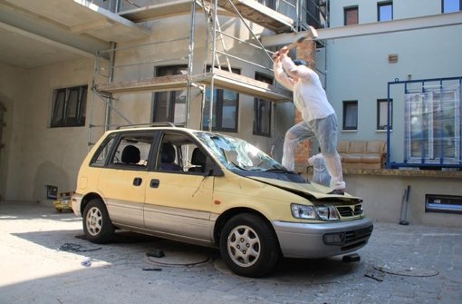 Vorschlaghammer marsch: Ein Kunde des Wutraums in Halle lässt seinen Frust an einem Auto aus Foto: prz