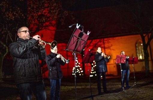 Vor der schön erleuchteten Peter- und Paulskirche spielt der Posaunenchor für das Videoprojekt „Köngener Weihnacht“. Foto: Ines Rudel