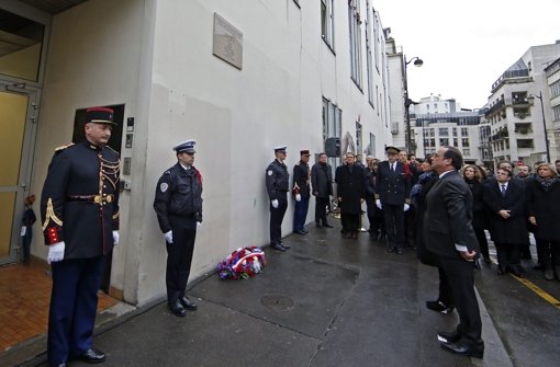Hollande steht vor einer Gedenktafel, die außen an der Charlie-Hebdo-Redaktion angebracht wurde. Foto: REUTERS POOL