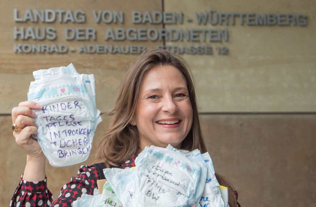 Die Vorsitzende der Tagesmütter in Baden-Württemberg, Christina Metke, protestiert in Stuttgart  mit beschrifteten Windeln vor dem Abgeordnetenhaus des baden-württembergischen Landtages.