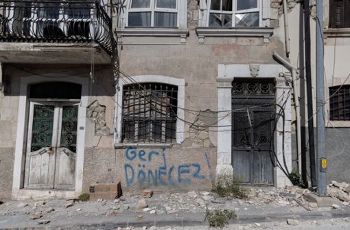 „Wir kommen wieder“ steht an einer Wand eines Hauses in Antakya, vor dem noch Trümmer des Erdbebens vor fast sechs Monaten liegen Foto: dpa/Bradley Secker