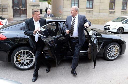 Der ehemalige Vorstandsvorsitzende der Porsche Automobil Holding SE, Wendelin Wiedeking (rechts) steigt zusammen mit seinem Anwalt Hanns Feigen (links) auf dem Weg zum Landgericht in Stuttgart aus einem Porsche Panamera. Foto: dpa
