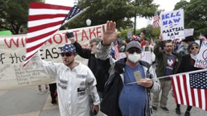 USA, Austin: Demonstranten versammeln sich mit US-Flaggen vor dem texanischen Kapitol, um gegen die Maßnahmen zur Eindämmung des Coronavirus zu protestieren. Foto: dpa/Eric Gay