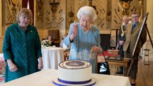 Die Queen schneidet die Torte an, die zu ihrem Platin-Jubiläums während eines Empfangs im Ballsaal von Sandringham House bereit steht Foto: dpa/Joe Giddens