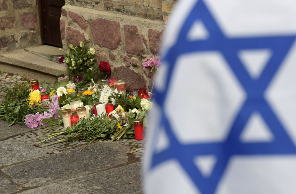 Blumen und Kerzen vor der Synagoge in Halle. Foto: AP/Jens Meyer