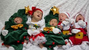 Ganz schön putzig: In einem Krankenhaus in Bangkok wurden Neugeborene in Weihnachtsmann- und Christbaumkostüme gesteckt. Foto: AP