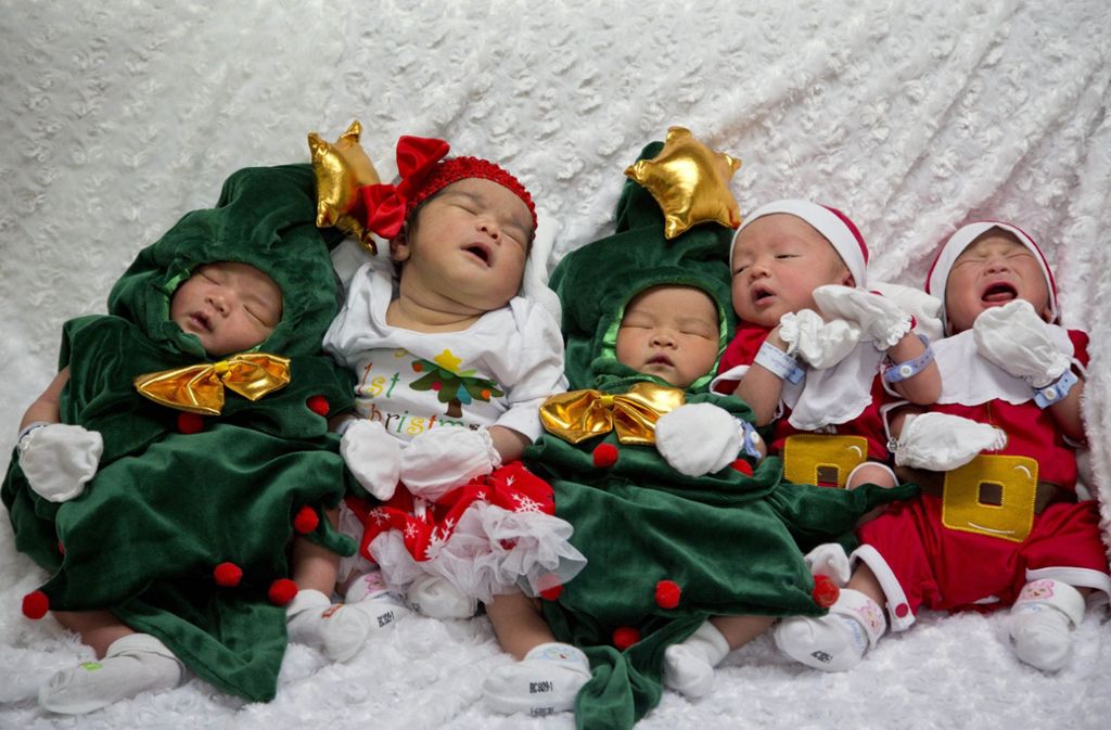 Ganz schön putzig: In einem Krankenhaus in Bangkok wurden Neugeborene in Weihnachtsmann- und Christbaumkostüme gesteckt.