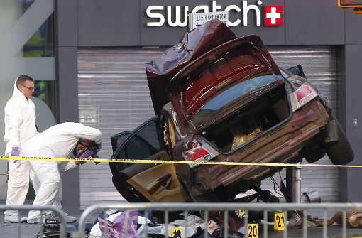 Polizisten untersuchen auf dem Times Square in New York ein zerstörtes Fahrzeug. Ein Autofahrer ist mit hohem Tempo über den Gehweg gerast und hat dabei eine Frau getötet und 22 weitere Menschen verletzt. Foto: AP