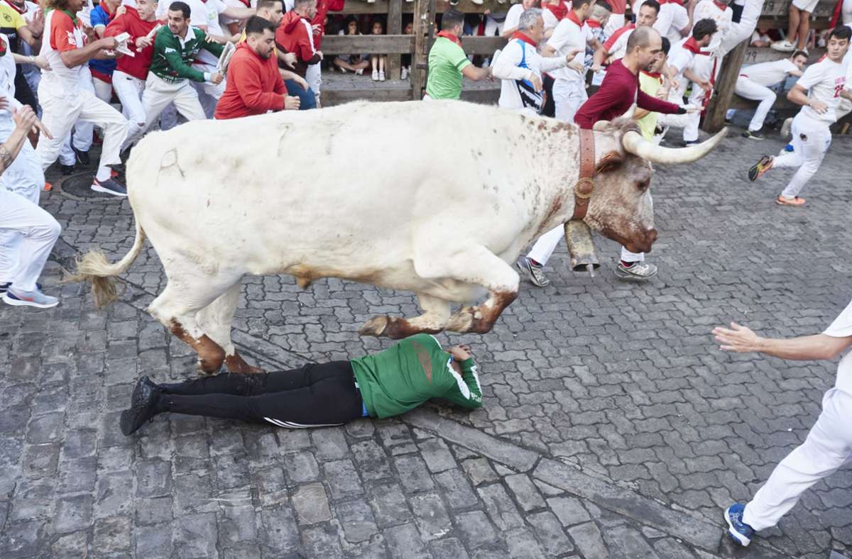 Ein Stier springt über einen Läufer beim „Sanfermines“-Fest bei der Stierhatz.