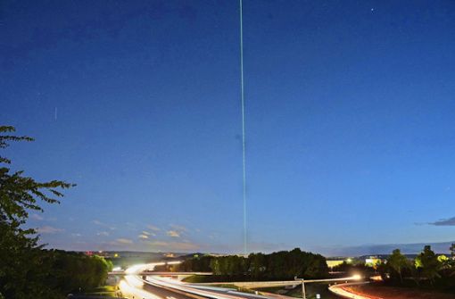 Der Trumpf-Laserstrahl schießt in den Nachthimmel: Einige schauen eigens am Firmentor in Ditzingen vorbei. Foto: Andreas Rosar