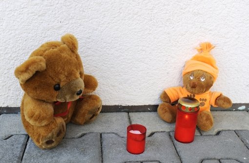Nachbarn haben Kerzen und Teddybären vor das Mehrfamilienhaus in Aldingen im Kreis Tuttlingen gelegt, in dem das verwahrloste Kleinkind tot aufgefunden worden war. Foto: dapd