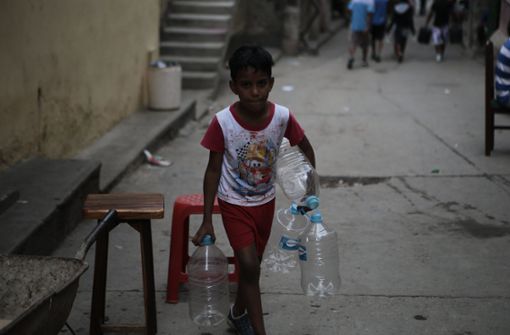 Ein Junge in Caracas macht sich auf den Weg um Wasser zu holen. Foto: dpa
