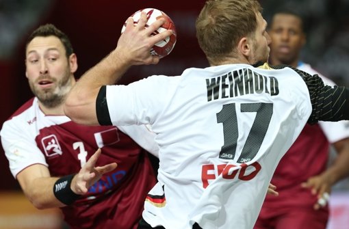 Deutschlands Steffen Weinhold (rechts) im Zweikampf gegen Bertrand Roine der Gastgebermannschaft. Foto: Qatar 2015 via epa