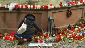 Eine Frau legt Blumen auf dem Marktplatz in Endingen für die getötete Joggerin nieder. Die 27 Jahre alte Frau war vergewaltigt und getötet worden. Foto: dpa