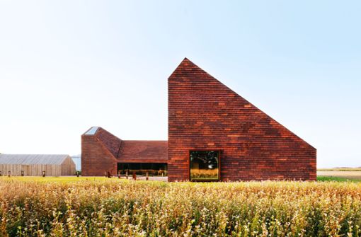 Warmes Rot passt zu Himmelblau: In Dänemark steht das „Kornets Hus“ von Reiulf Ramstad Architekten. Foto: Verlag Gestalten Brick by Brick/Reiulf Ramstad Arkitekter