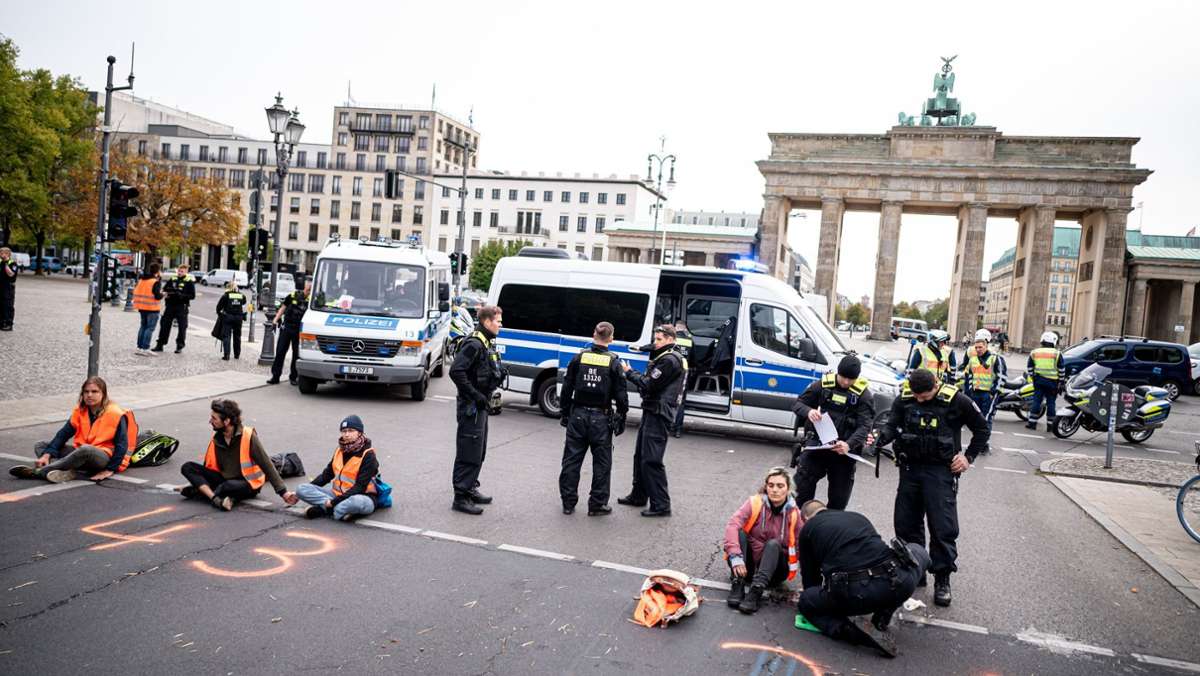 „Letzte Generation“ in Berlin: Klima-Aktivisten kleben sich vor Brandenburger Tor auf die Straße