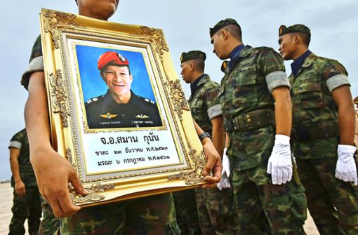 Ein thailändischer Marinetaucher hält das Porträt des verstorbenen Saman Gunan hoch. Foto:  