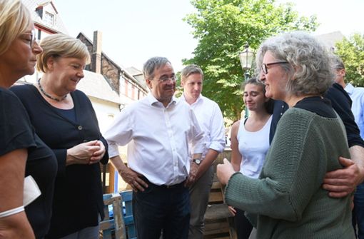 Kanzlerin Angela Merkel und NRW-Ministerpräsident Armin Laschet im Gespräch mit Betroffenen der Flutkatastrophe in Bad Münstereifel. Foto: dpa/Christof Stache