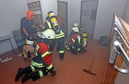 Beim simulierten Brandort wird ein Eingeschlossener gefunden: Die Hemminger Feuerwehr im Übungseinsatz im Keller der Gemeinschaftshalle. Foto: factum/Bach