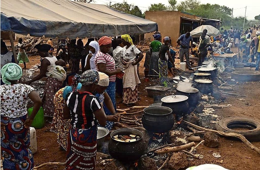 In großen Töpfen werden auf einem Platz in Kongoussi  Reis und Hirse für die vielen Flüchtlinge gekocht.