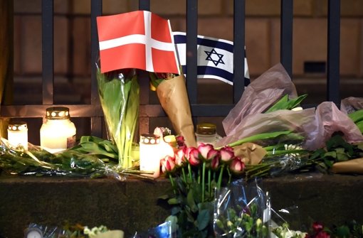 Trauernde haben Blumen und Kerzen an der Synagoge in der Kopenhagener Innenstadt niedergelegt. Ein 22-Jähriger soll dort einen 37 Jahre alten Wachmann erschossen haben. Foto: dpa