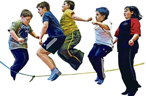 Übergewichtige Kinder hüpfen beim Seilspringen in der Turnhalle einer Schule. Foto: dpa/Waltraud Grubitzsch