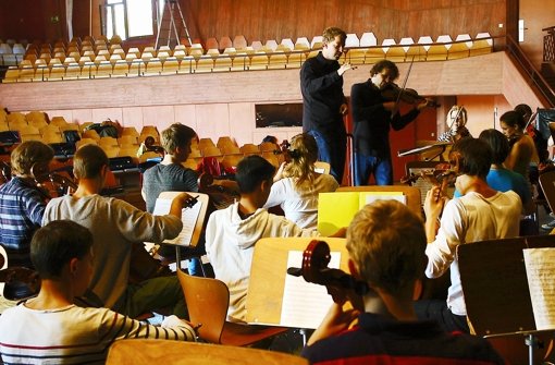 Jörg Halubek (links) und Konzertmeister Martin Jopp zeigen den Schülern, wie Händels Messias klingen soll. Foto:  
