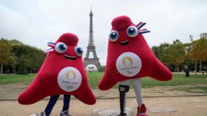 Die Maskottchen der Olympischen (l) und Paralympischen Spiele in Paris stehen vor dem Eiffelturm. Foto: Michel Euler/AP/dpa