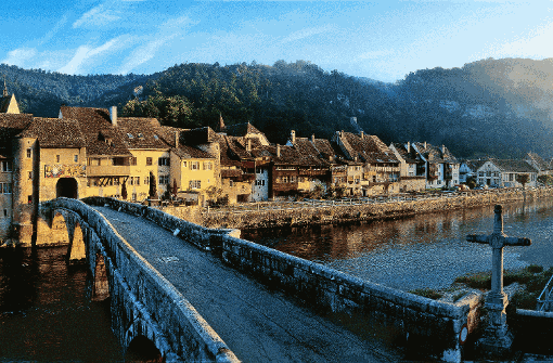 Mit der spätromanischen Stiftskirche, den schmucken Häusern und der alten Steinbrücke gilt Saint-Ursanne am Doubs als Perle des Jura. Foto: Christof Sonderegger/Schweiz Tourismus