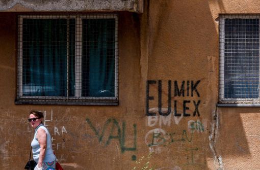 Bei den Kosovaren ist „Eulex“ nicht beliebt – eine Frau vor einem Graffito in der Hauptstadt Pristina. Foto: AFP