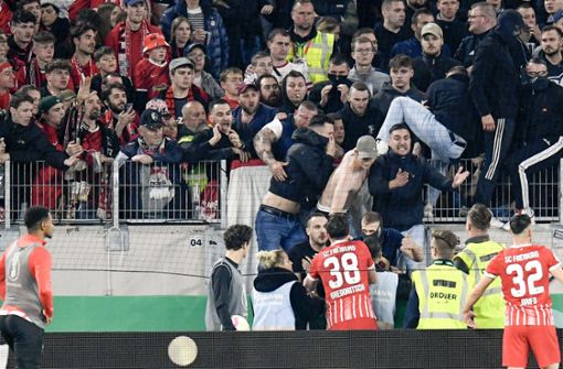 Einige Fans des SC Freiburg wollten das Spielfeld stürmen. Foto: AFP/THOMAS KIENZLE