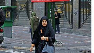 Eine iranische Frau  vor den Wahlplakaten in der Hauptstadt Teheran Foto: AP