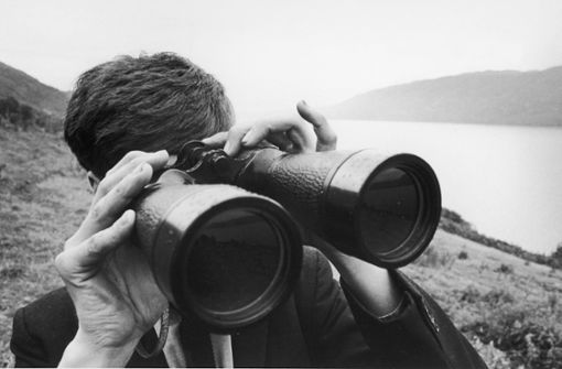 Ein Mann steht am Ufer des Loch Ness und hält Ausschau nach dem gleichnamigen Ungeheuer: Allen Wiederlegungsversuchen zum Trotz zweifeln wahre „Nessie“-Fans nicht an der Existenz des Ungeheuers von Loch Ness. Foto: Imago/Gemini Collection