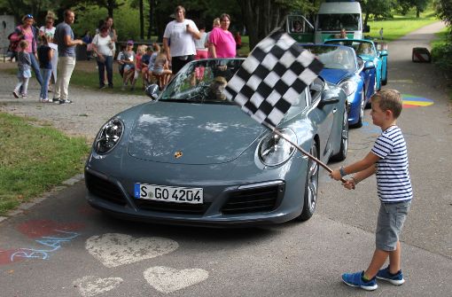 Der fünfjährige  Finn schwenkt die Startflagge, und gleich geht es los: Drei Porsche 911 Carrera mit zusammen mehr als 1000 PS setzen sich in Bewegung. Foto: Bernd Zeyer