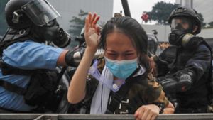 Bereitschaftspolizisten gehen in Hongkong gegen eine Demonstrantin vor. Foto: dpa/Kin Cheung