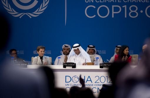 Der katarische Konferenzpräsident Abdullah bin Hamad Al-Attijah (Mitte) verkündet auf der 18. UN-Klimakonferenz die Verlängerung des Kyoto-Abkommens. Foto: dapd