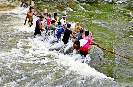 In einer Vorstadt Colombos versuchen Einwohner, sich nach sintflutartigen Regenfällen in Sicherheit zu bringen. Foto: EPA