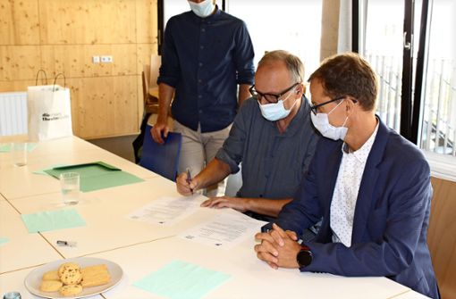 Burkhard Kosminski (links) und Christoph Mühlthaler unterzeichnen. Foto: Jacqueline Fritsch