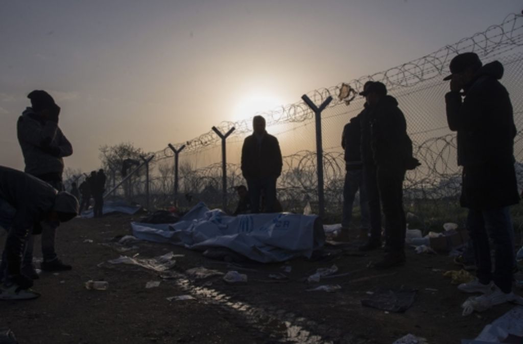 Flüchtlinge warten an der griechisch-mazedonischen Grenze. Foto: dpa