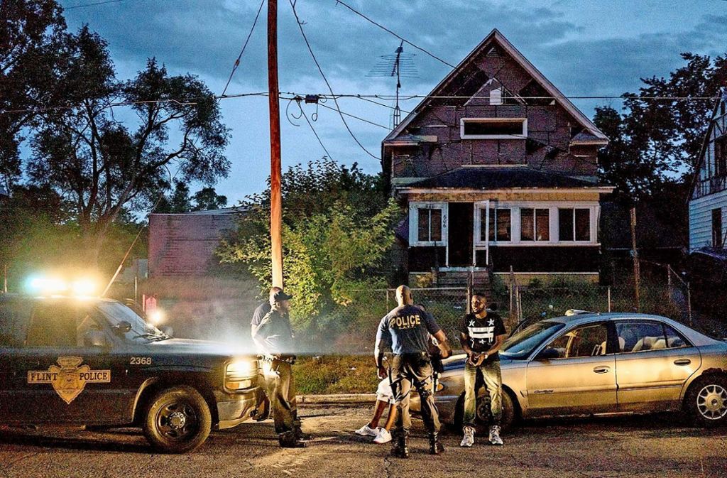 Vor einem Abbruchhaus in Flint nimmt die Polizei Drogendealer in Gewahrsam.